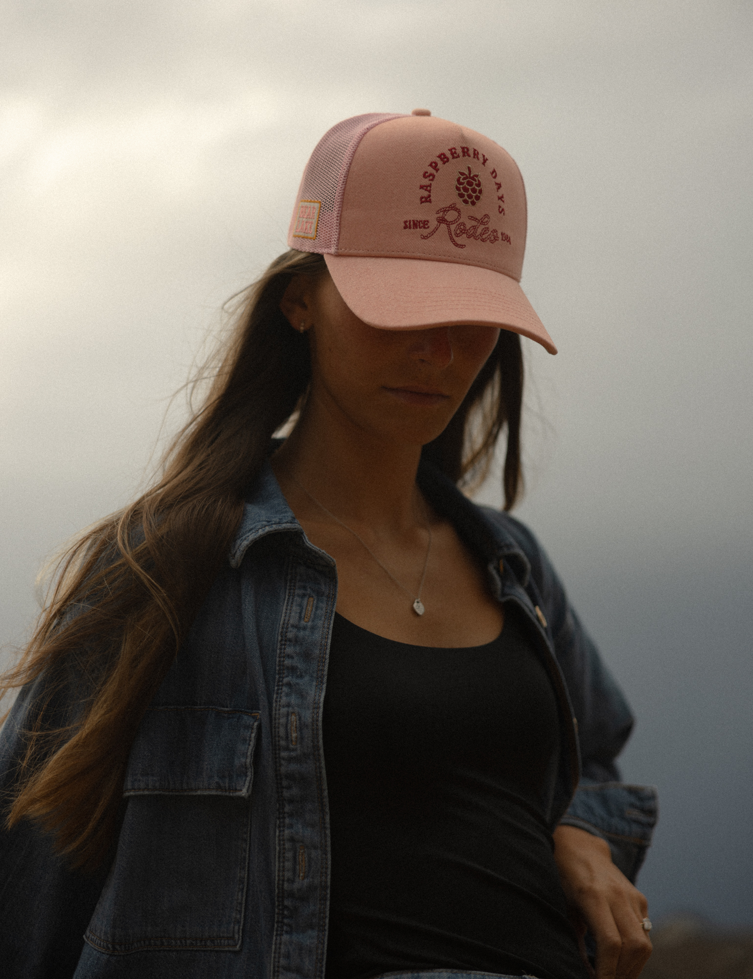 Portrait of a model wearing a pink Raspberry Days Rodeo hat in soft evening light