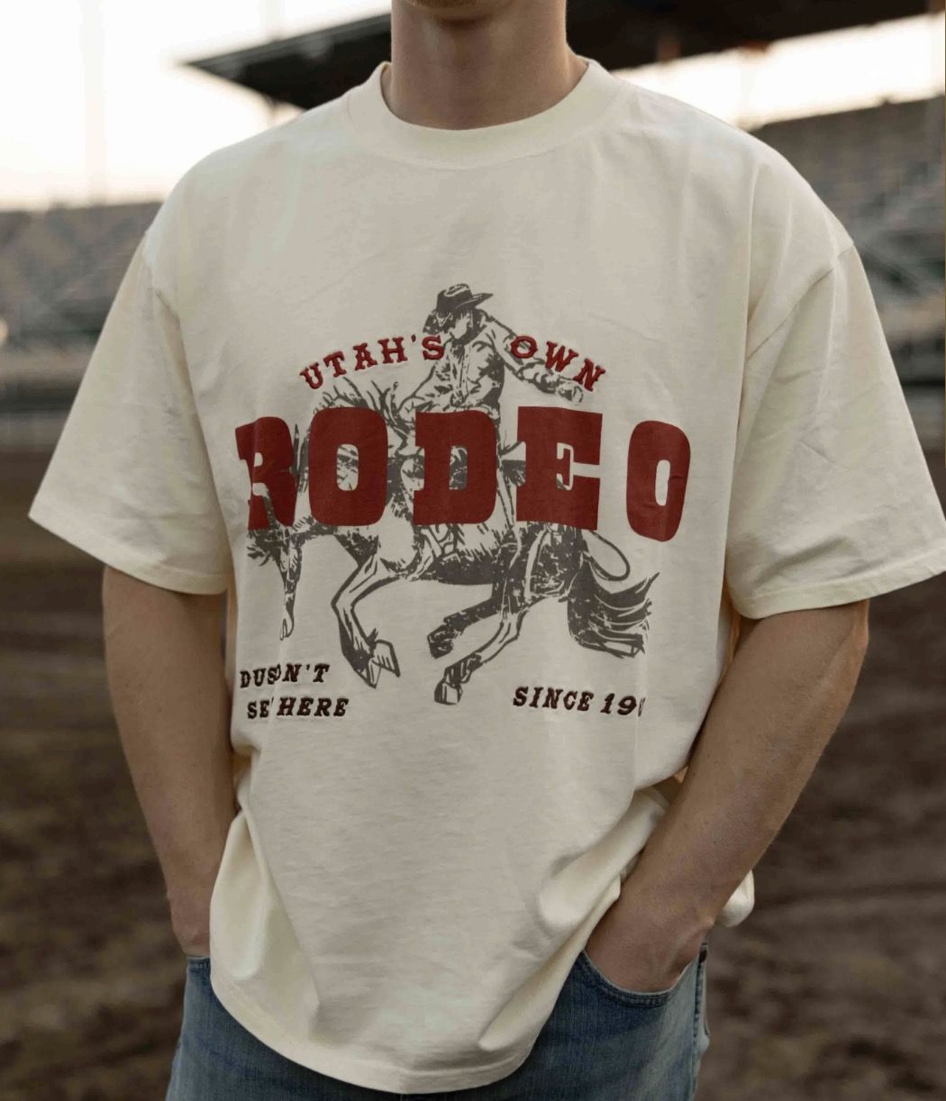 Cream Utah's Own Rodeo tee with a red bucking-horse graphic worn at the arena