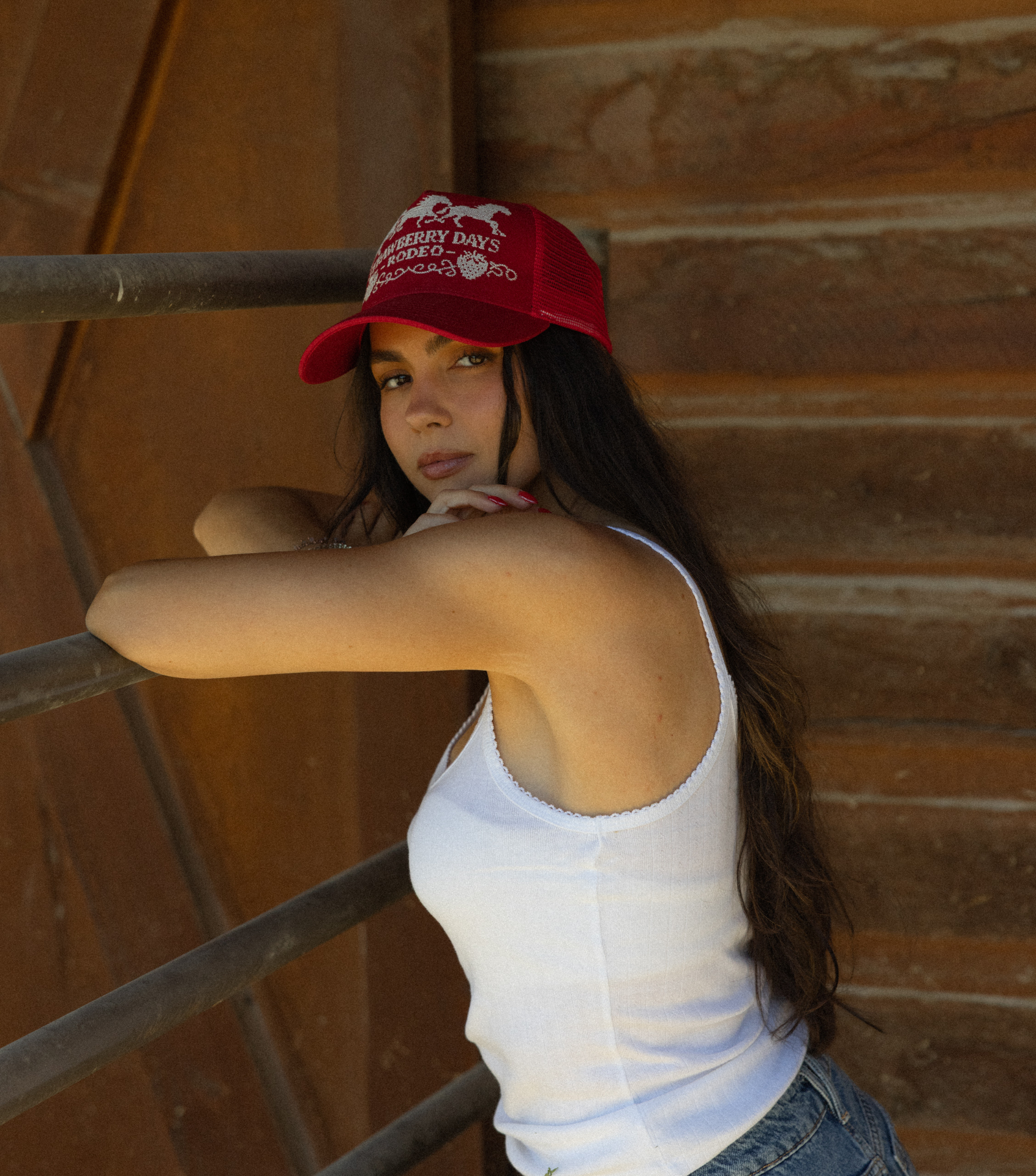 Woman in custom Strawberry Days Rodeo trucker hat